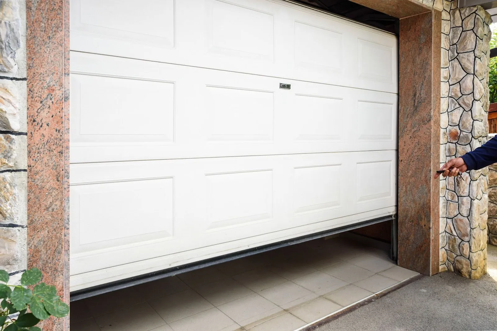 A man standing in front of a garage door, showcasing garage door replacement options.