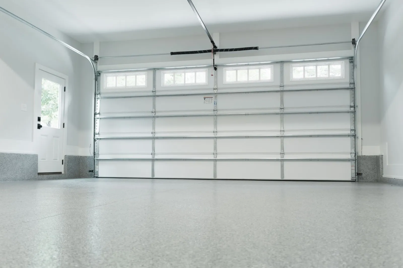 A white garage door with an opener, symbolizing professional garage door repair and solutions for common garage door issues.
